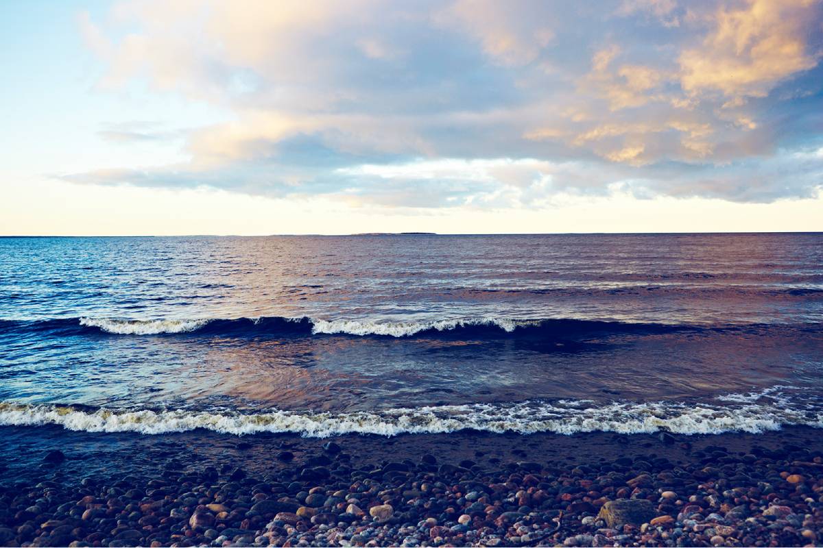 Vy mot havet. Vågor rullar mjukt in.